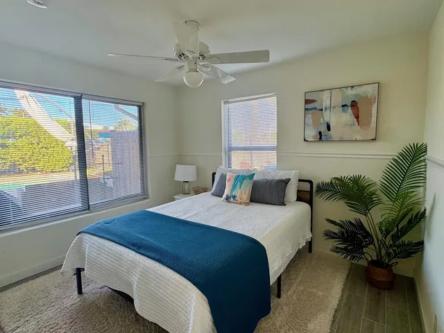 a spacious bedroom with a large bed and a chandelier