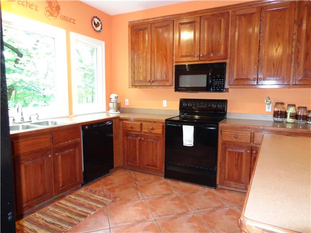 4651 Heath Road Nashville, TN 37221 - Photo 7 of 20 Kitchen has terra cotta tile and natural wood cabinetry