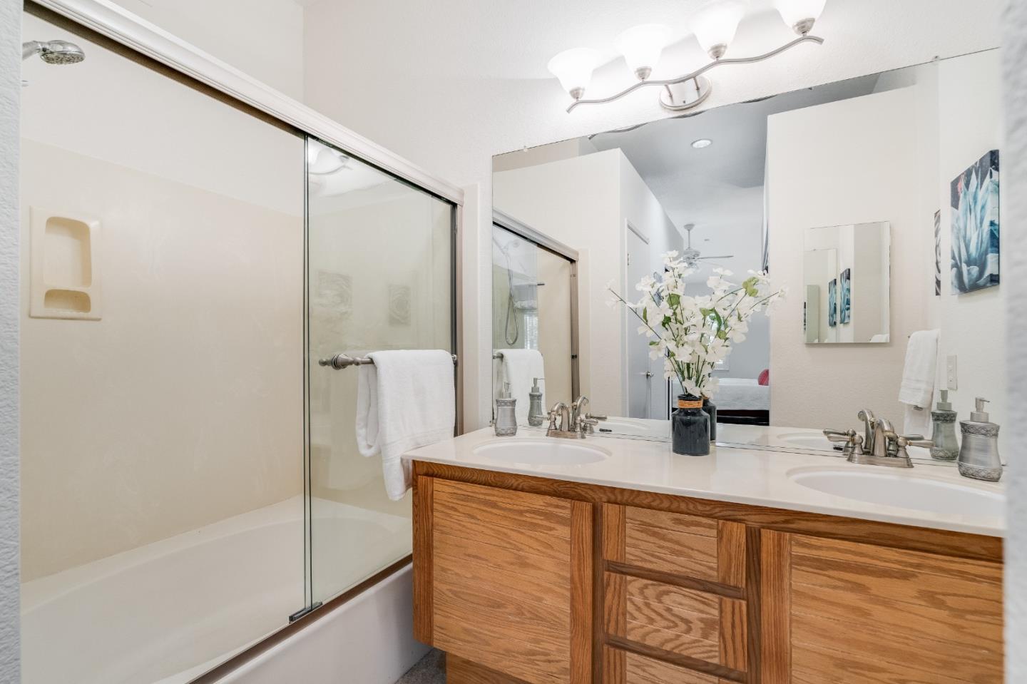 6936 Gregorich Drive, Unit E San Jose, CA 95138 - Photo 23 of 44 a bathroom with a double vanity sink mirror and shower
