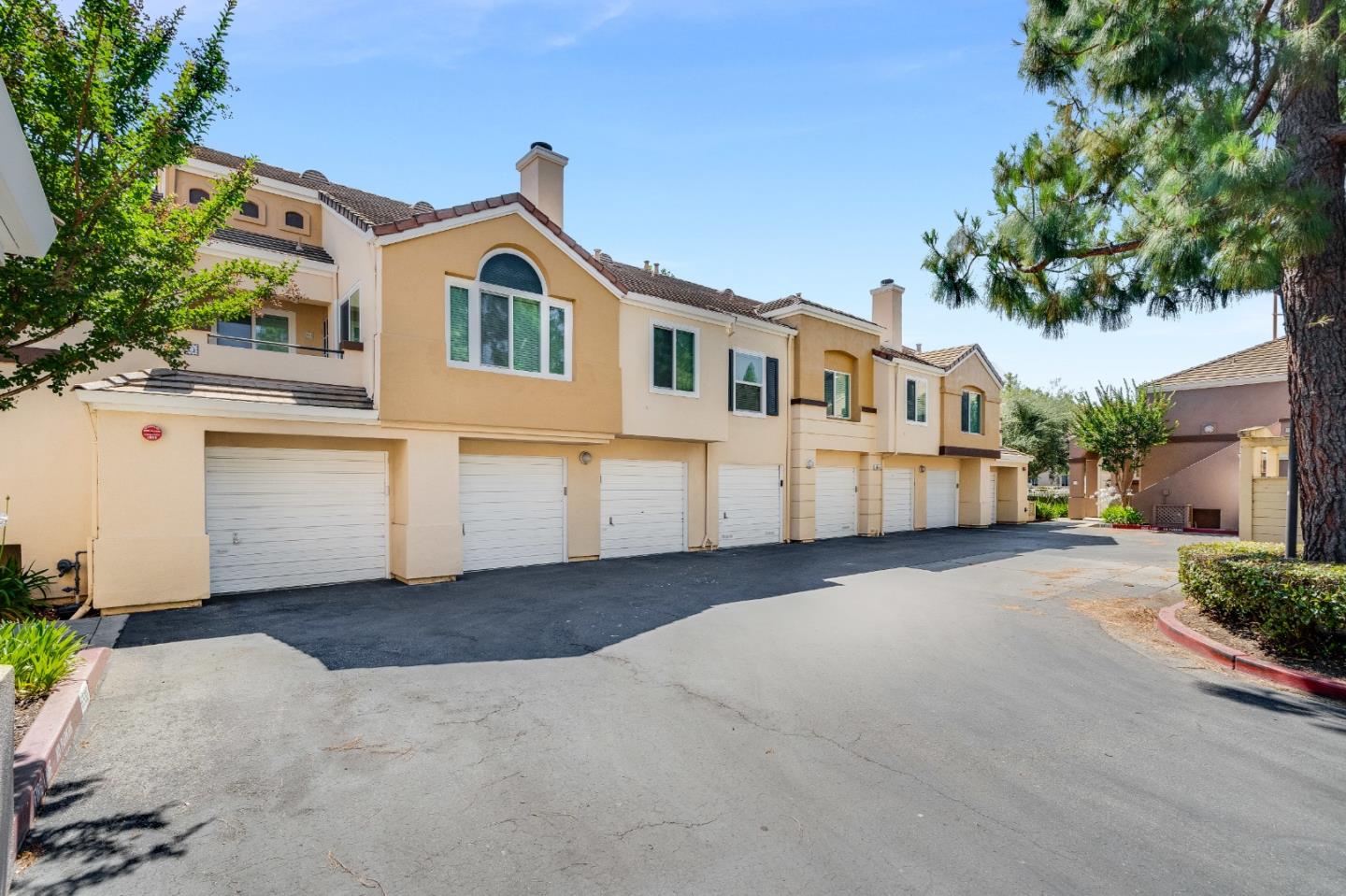 6936 Gregorich Drive, Unit E San Jose, CA 95138 - Photo 31 of 44 a front view of a house with a yard and garage