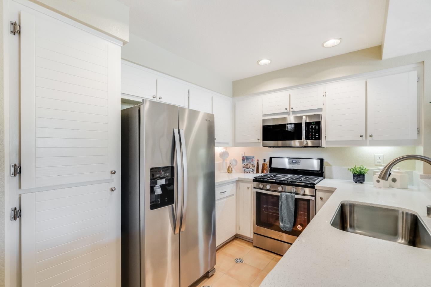 6936 Gregorich Drive, Unit E San Jose, CA 95138 - Photo 8 of 44 a kitchen with stainless steel appliances a refrigerator stove and microwave
