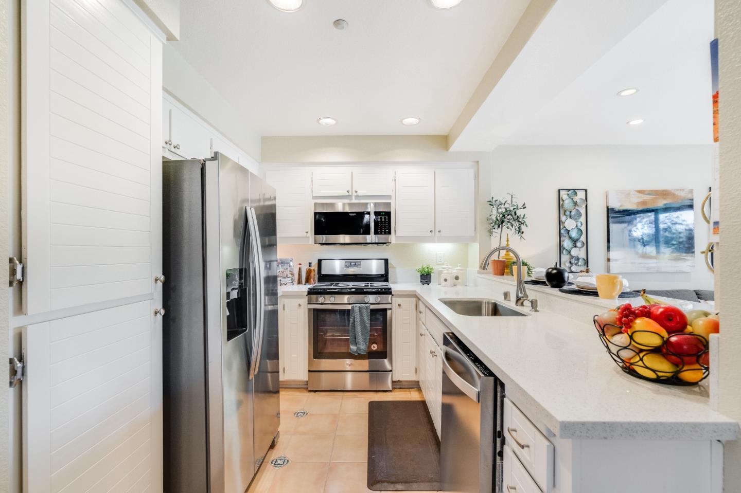 6936 Gregorich Drive, Unit E San Jose, CA 95138 - Photo 9 of 44 a kitchen with stainless steel appliances kitchen island granite countertop a sink and refrigerator