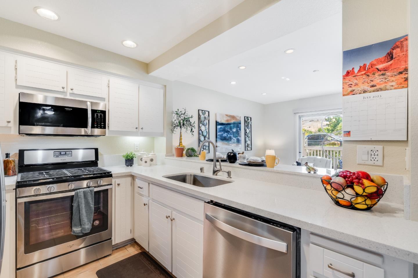 6936 Gregorich Drive, Unit E San Jose, CA 95138 - Photo 10 of 44 a kitchen with stainless steel appliances a stove a sink and a microwave
