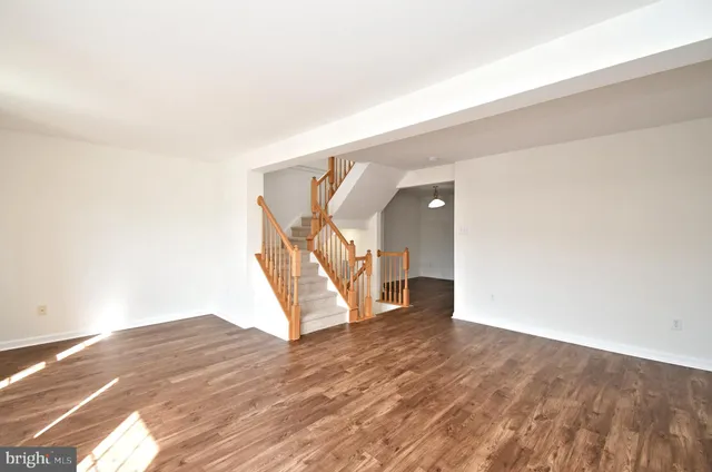 a kitchen with stainless steel appliances granite countertop a refrigerator a sink dishwasher a stove and white countertops with wooden floor