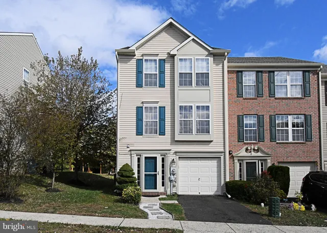 a view of a white house with large windows and a yard