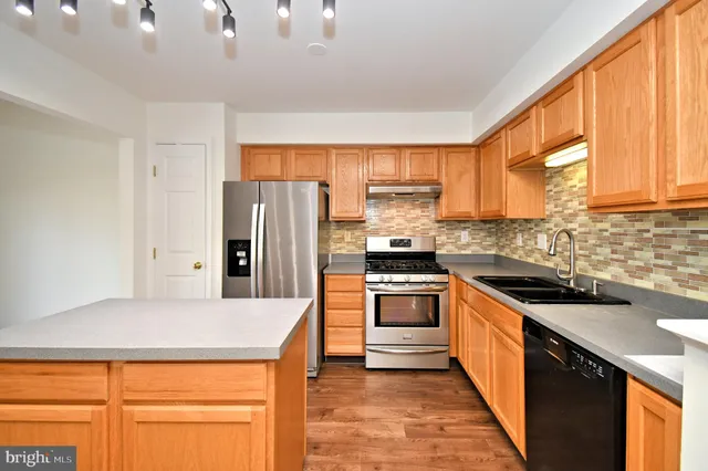 a view of a kitchen island a sink dishwasher and cabinets