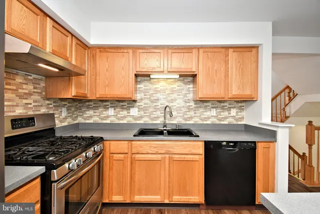 a kitchen with a refrigerator and a stove top oven