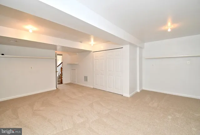 a view of an empty room with wooden floor and window
