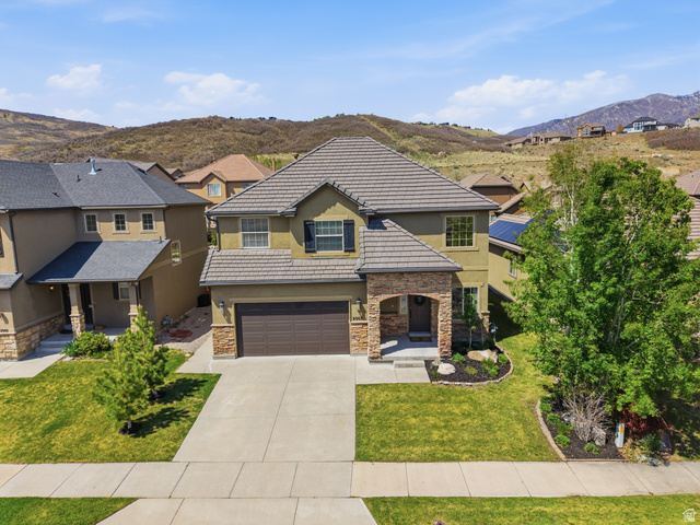 2007 Fielding Hill Lane Draper, UT 84020 - Photo 2 of 83 Two-story residence featuring a tile roof, stone and stucco exterior, an integrated two-car garage, and landscaped front yard with mature trees