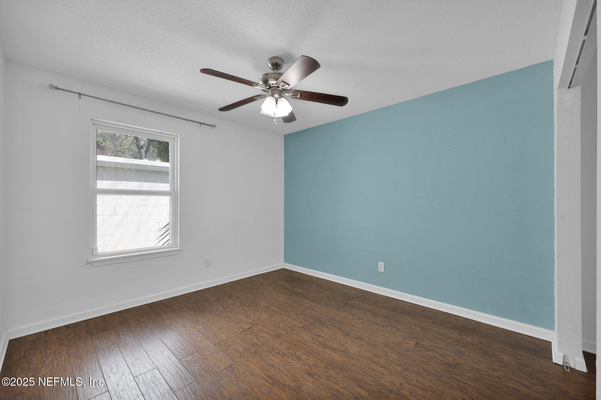 5455 Spring Brook Road Jacksonville, FL 32277 - Photo 11 of 21 an empty room with wooden floor fan and windows