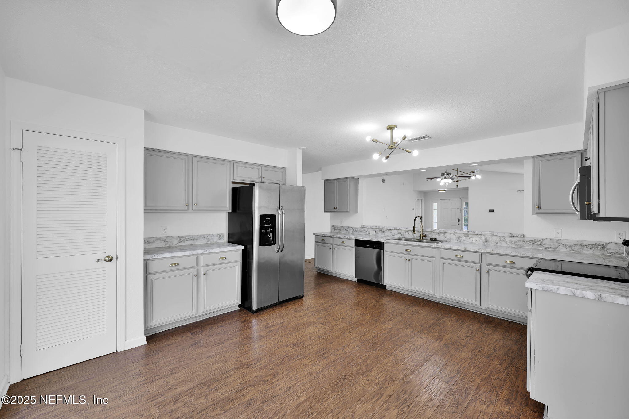 5455 Spring Brook Road Jacksonville, FL 32277 - Photo 8 of 21 a large kitchen with cabinets wooden floor and stainless steel appliances