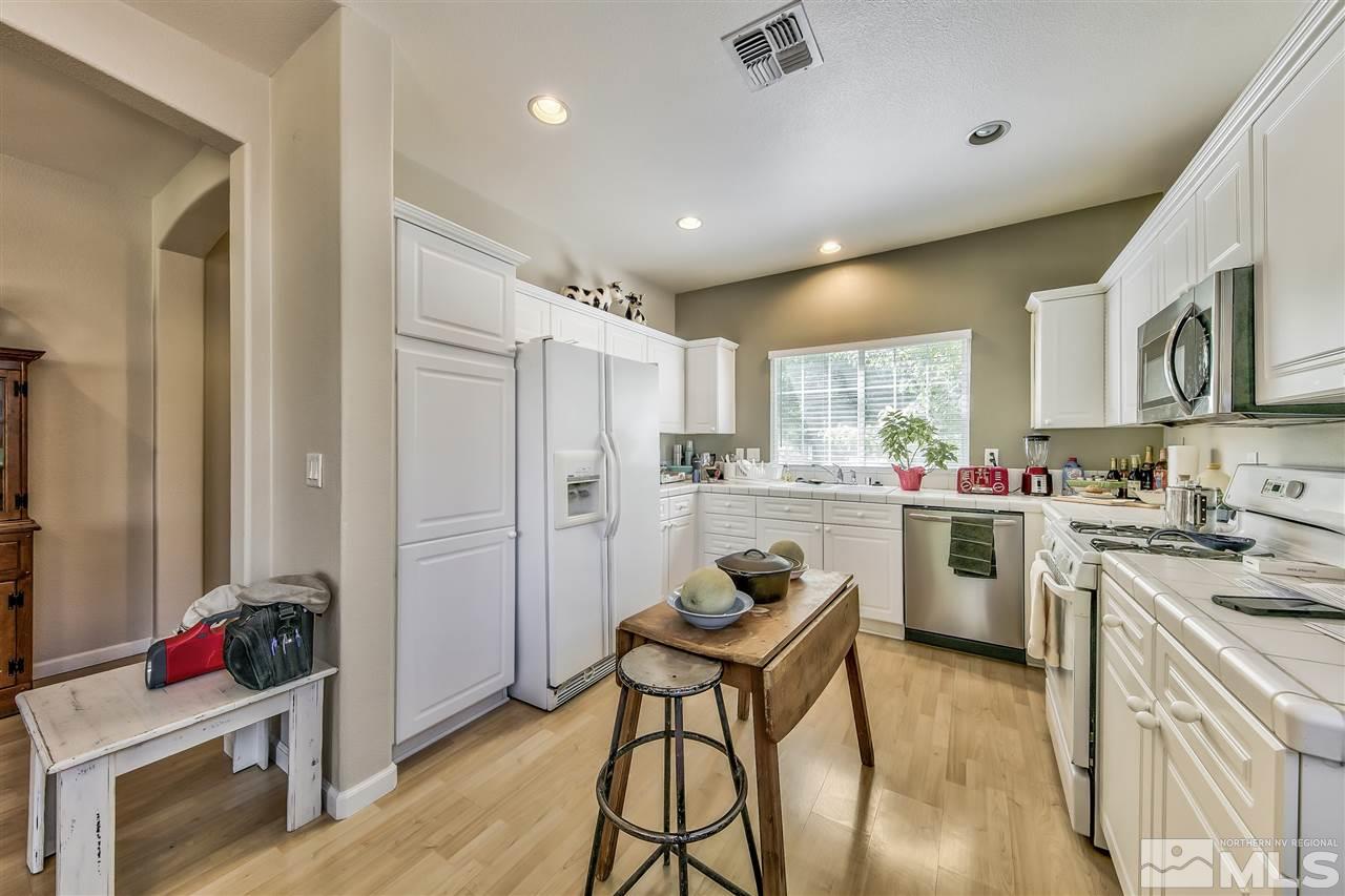 10680 Arbor Way Reno, NV 89521 - Photo 4 of 16 a kitchen that has a lot of cabinets in it and wooden floors
