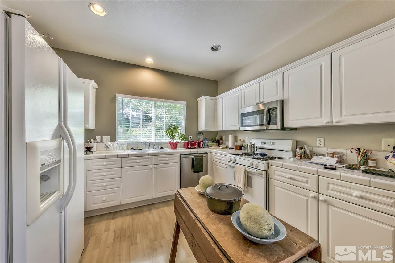 10680 Arbor Way Reno, NV 89521 - Photo 5 of 16 a kitchen with a sink stove and white cabinets