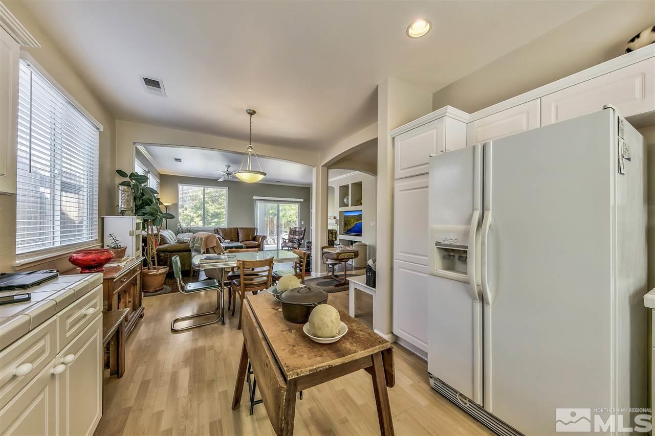 10680 Arbor Way Reno, NV 89521 - Photo 6 of 16 a very nice looking open dining room with kitchen island furniture a refrigerator and a window