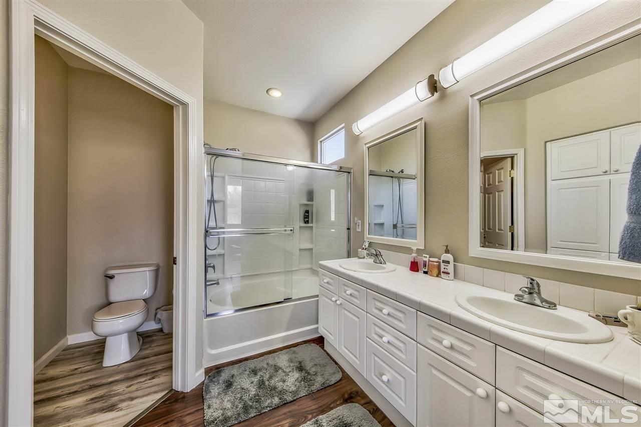 10680 Arbor Way Reno, NV 89521 - Photo 9 of 16 a bathroom with a double vanity sink mirror and toilet