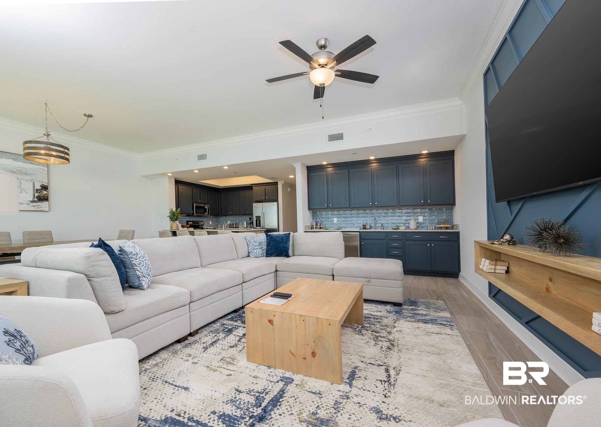 23008 Perdido Beach Boulevard, Unit 506 Orange Beach, AL 36561 - Photo 9 of 48 Living area with visible vents, ornamental molding, a ceiling fan, wet bar, and light wood finished floors