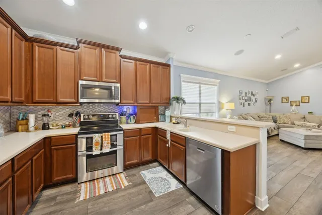 a kitchen with stainless steel appliances granite countertop a sink and cabinets with wooden floor