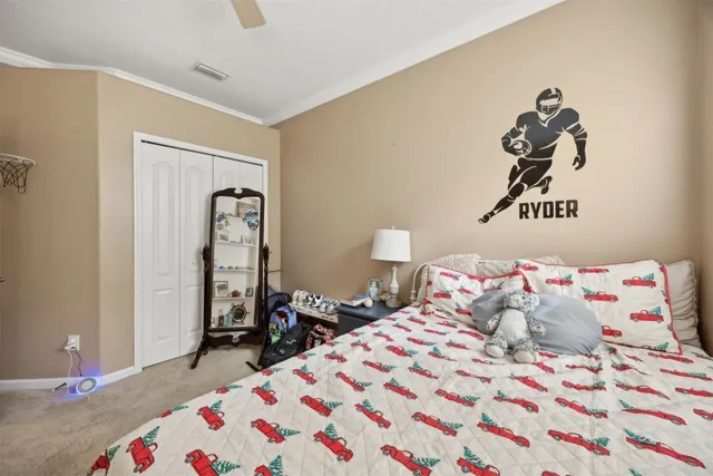 a bedroom with a bed and a flat tv screen on a dresser