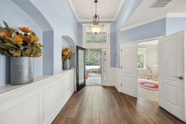 a view of a hallway with wooden floor and windows