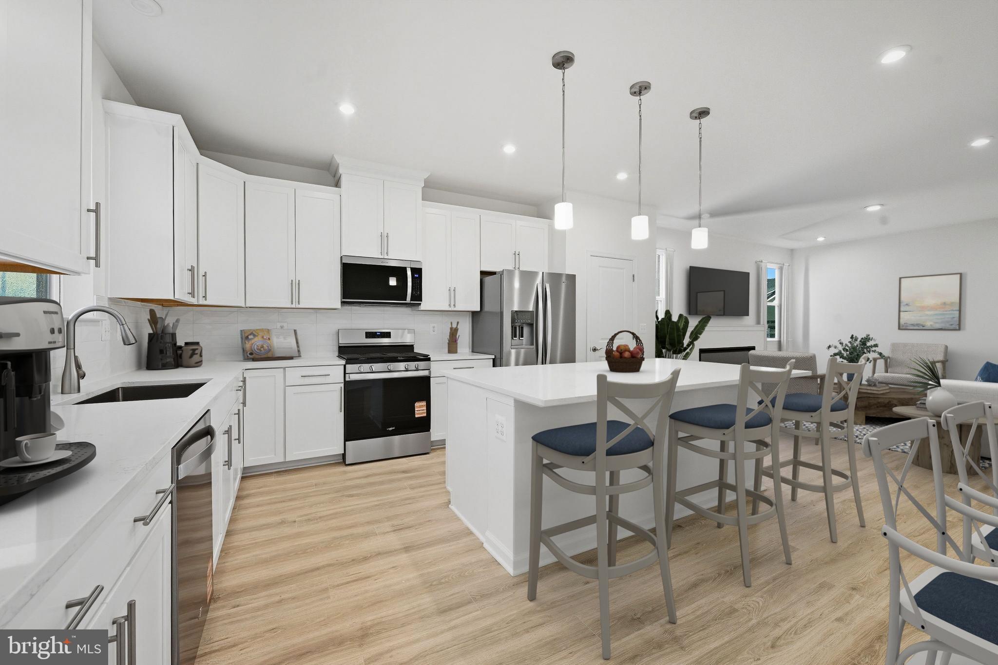 25013 Cypress Court Lewes, DE 19958 - Photo 14 of 24 a kitchen with stainless steel appliances kitchen island granite countertop a stove top oven a sink a dining table and chairs with wooden floor