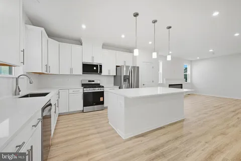 a kitchen with white cabinets sink and stainless steel appliances