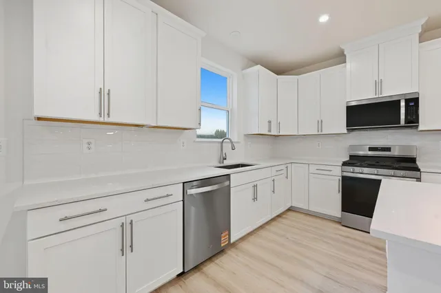 a kitchen with stainless steel appliances granite countertop a stove a refrigerator and a microwave