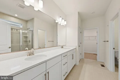 a bathroom with a double vanity sink and a mirror