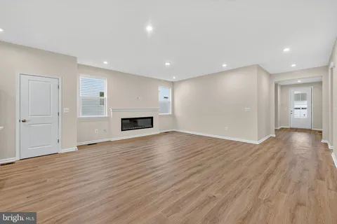 a view of empty room with wooden floor and fireplace
