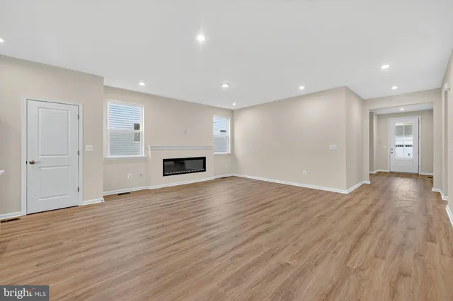 a view of empty room with wooden floor and fireplace