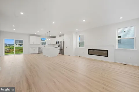 a view of empty room with wooden floor and window