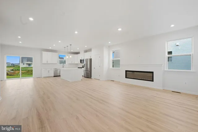 a view of empty room with wooden floor and window