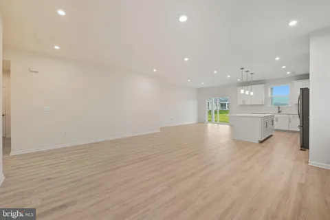 a view of an empty room with wooden floor and closet