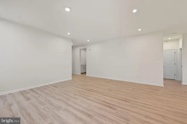 a kitchen with stainless steel appliances kitchen island granite countertop a refrigerator a stove a sink a dining table and chairs with wooden floor