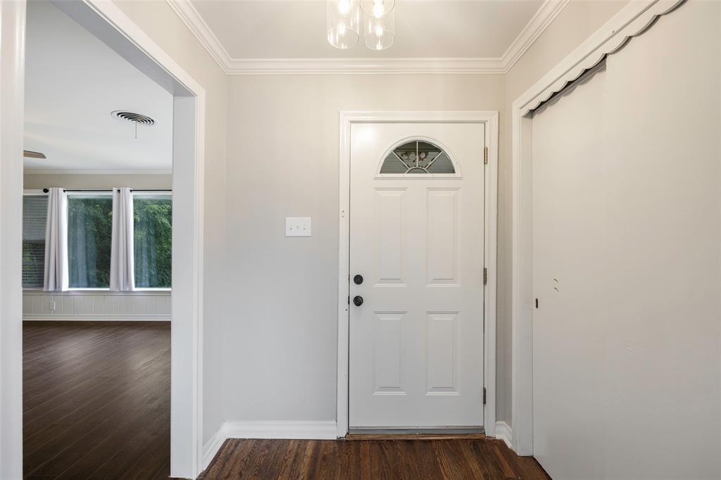 2323 Sutter Street Dallas, TX 75216 - Photo 4 of 30 Doorway to outside with dark hardwood / wood-style flooring, a chandelier, and crown molding