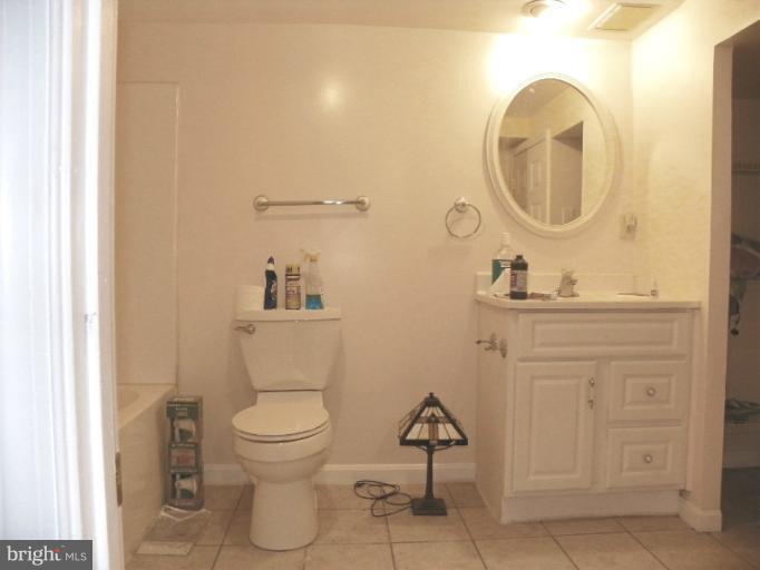 187 Inlet Drive Pasadena, MD 21122 - Photo 25 of 29 a bathroom with a toilet a sink and a mirror