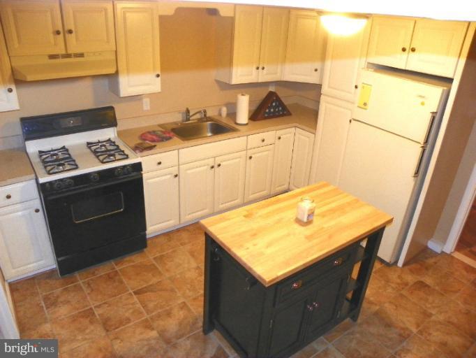 187 Inlet Drive Pasadena, MD 21122 - Photo 7 of 29 a kitchen with sink cabinets and stove