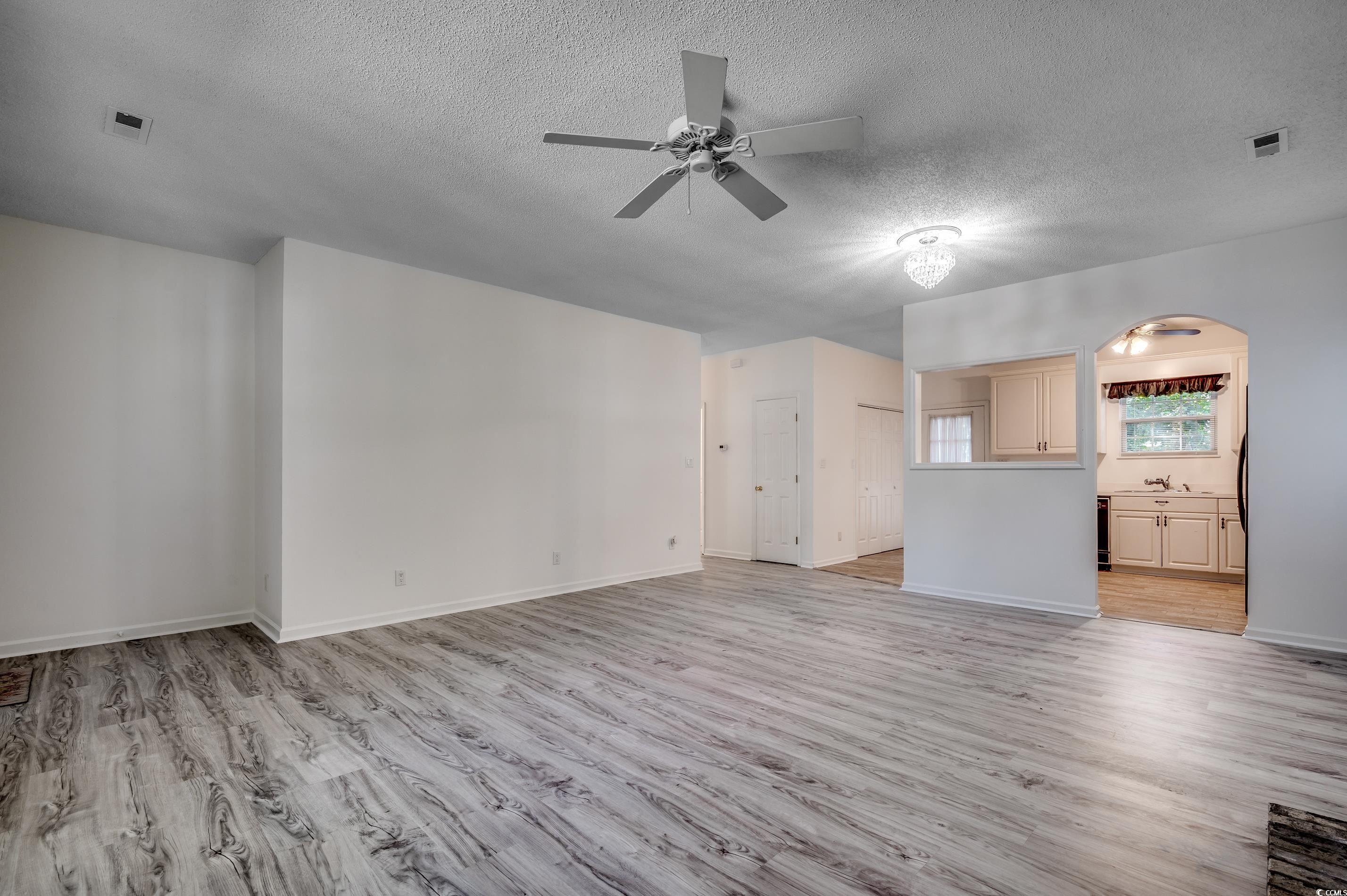 4261 Brook Drive Murrells Inlet, SC 29576 - Photo 6 of 39 Unfurnished living room with ceiling fan, a textur