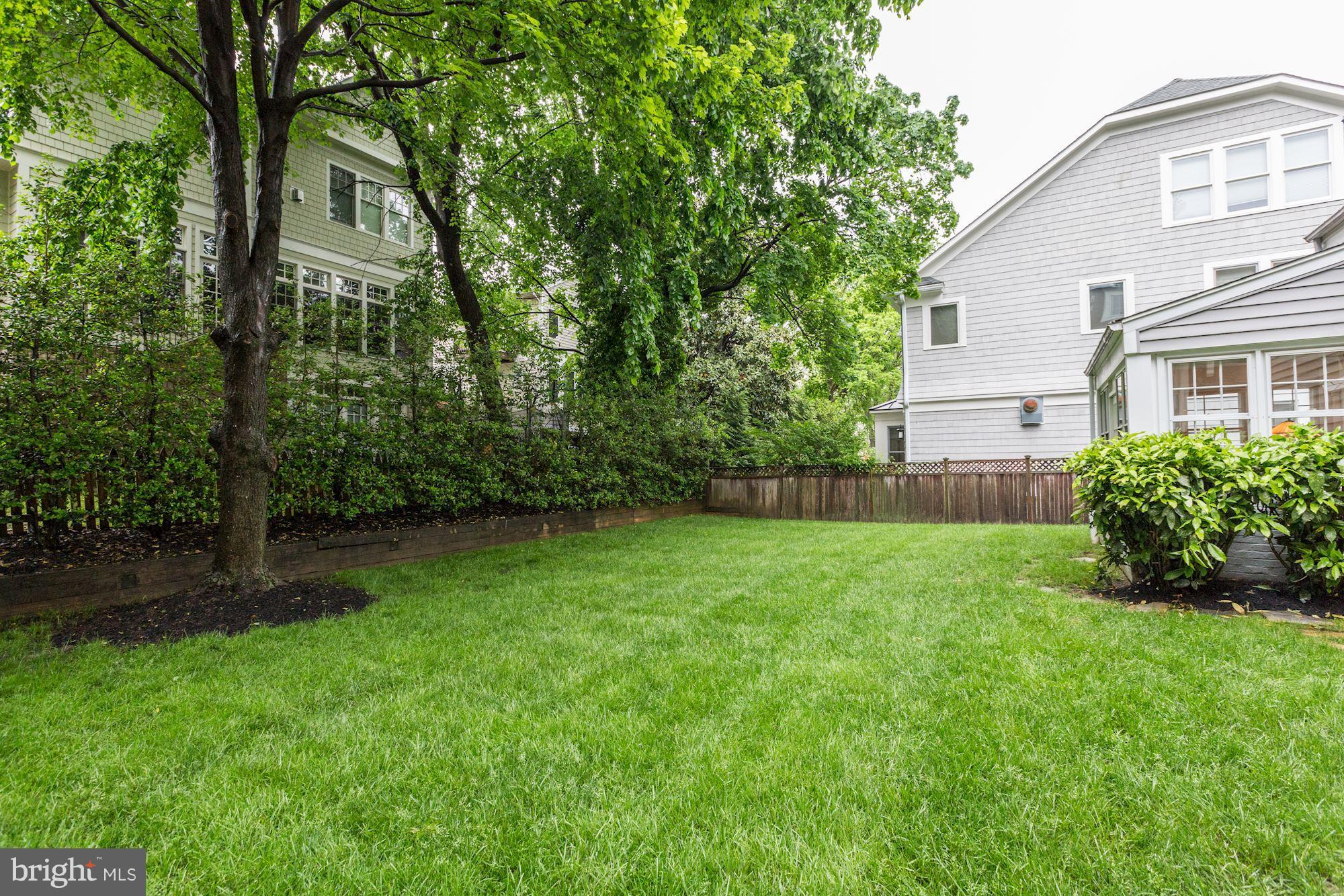 7105 Fairfax Road Bethesda, MD 20814 - Photo 2 of 17 a view of a backyard with potted plants and large trees