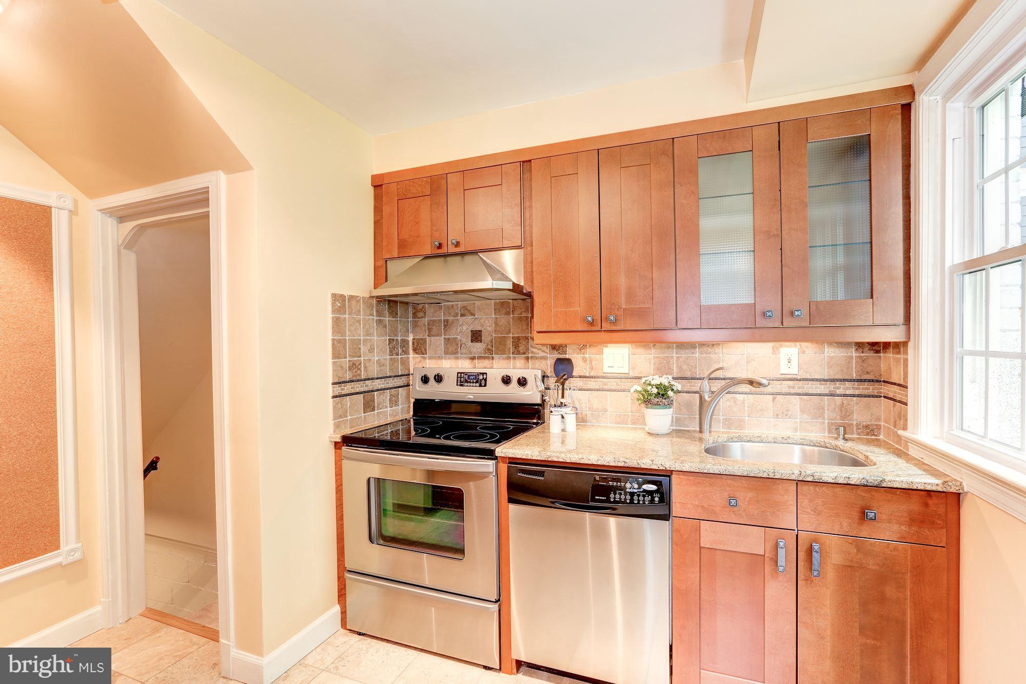 7105 Fairfax Road Bethesda, MD 20814 - Photo 7 of 17 a kitchen with stainless steel appliances granite countertop a stove and a white cabinets