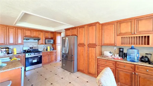 a kitchen with stainless steel appliances granite countertop a refrigerator and a stove top oven
