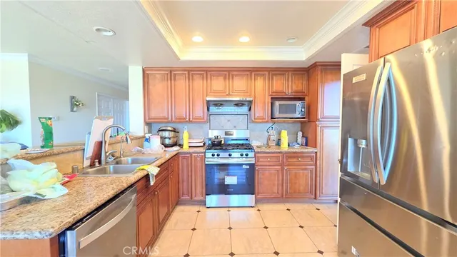 a kitchen with stainless steel appliances granite countertop a refrigerator a stove and a sink