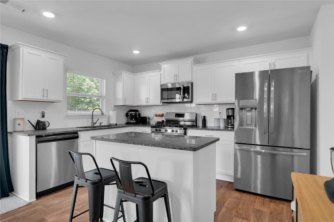 34 Karkinnen Court Pendleton, SC 29670 - Photo 12 of 36 A well-lit culinary space showcases an island with counter seating and modern stainless steel appliances.