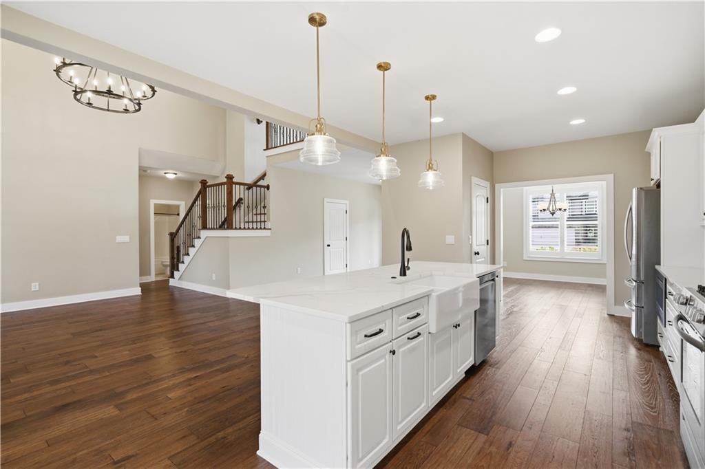 12 Bridgestone Way Cartersville, GA 30120 - Photo 3 of 46 a large kitchen with stainless steel appliances a large counter top a sink a refrigerator and a wooden floor