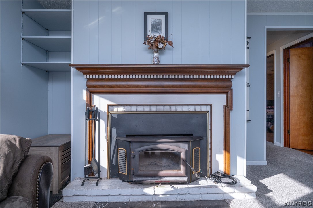 6463 Ward Road Sanborn, NY 14132 - Photo 12 of 49 A classic fireplace with a detailed wood mantel anchors the cozy living area.