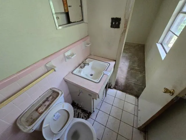 a bathroom with a toilet and a mirror