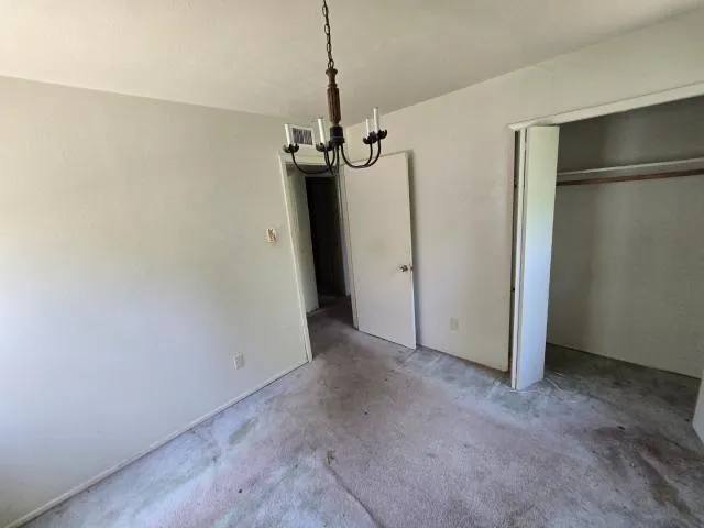 a view of empty room with a chandelier fan