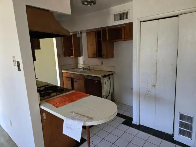 a kitchen with a sink a refrigerator and cabinets