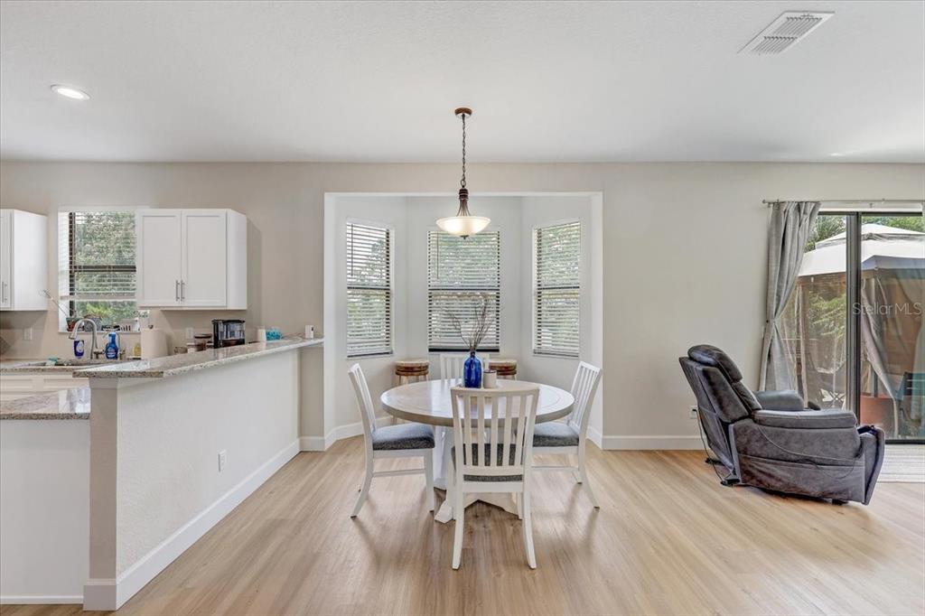 7314 Madrid Road Weeki Wachee, FL 34613 - Photo 8 of 54 a dining room with furniture a chandelier and wooden floor