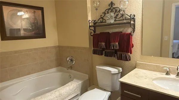 a bathroom with a granite countertop sink mirror vanity and toilet