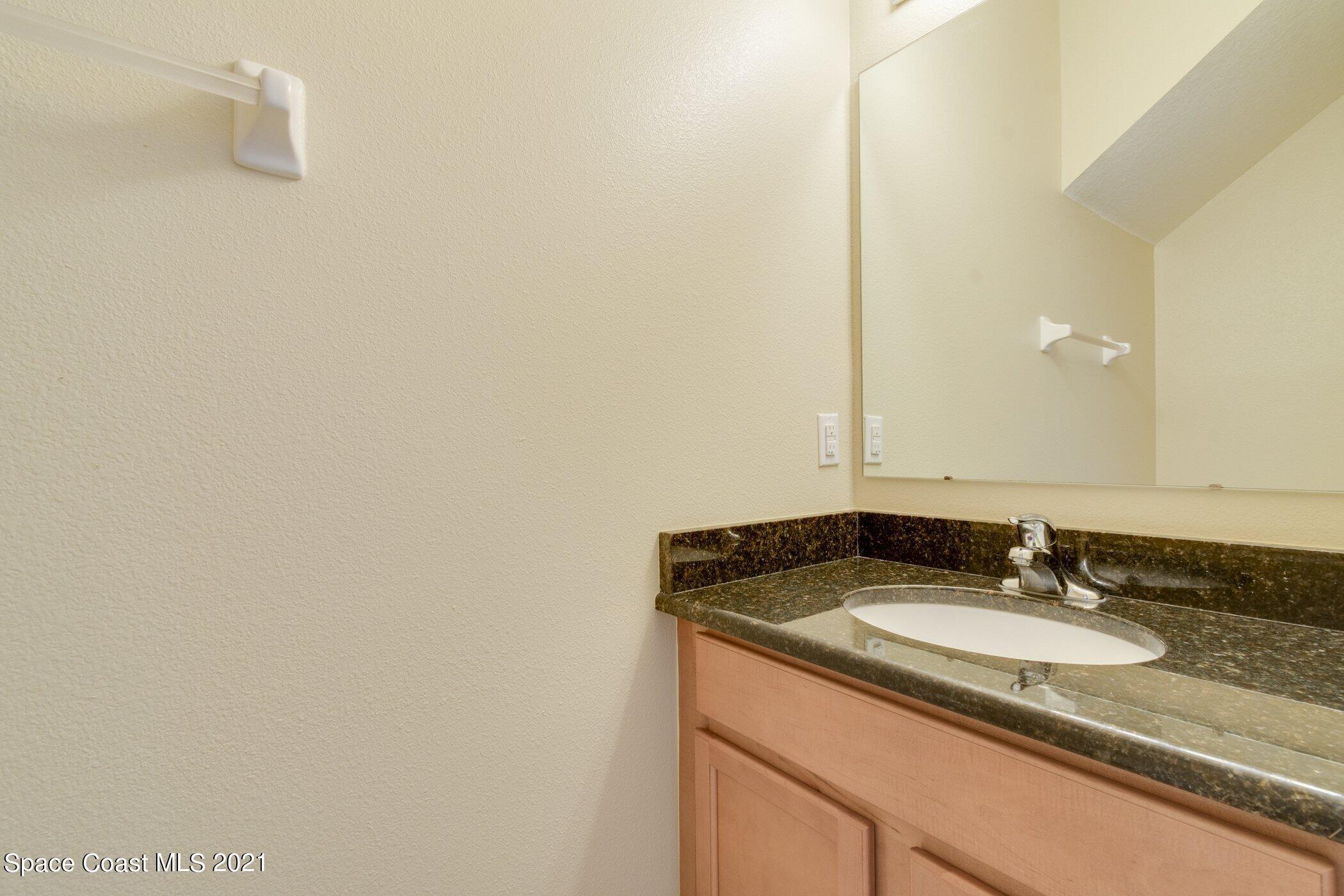 2780 Reston Street, Unit 102 Melbourne, FL 32935 - Photo 12 of 36 a bathroom with a granite countertop sink and a mirror